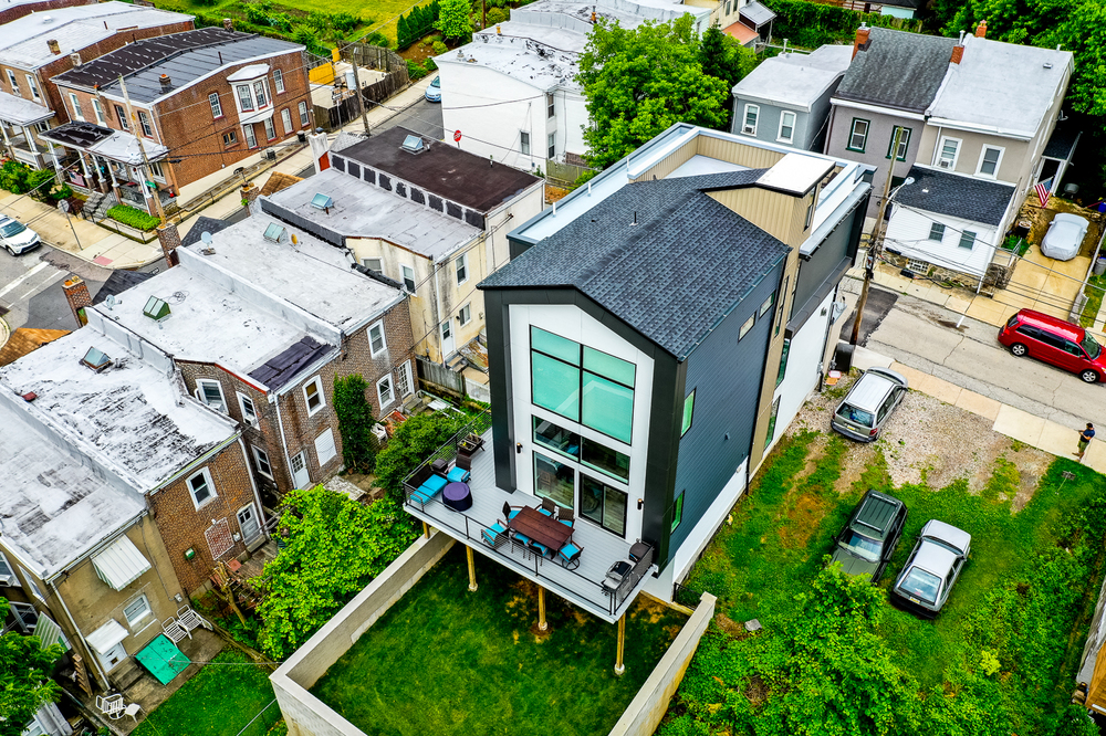 A building with a lawn and vehicles parked in the back.