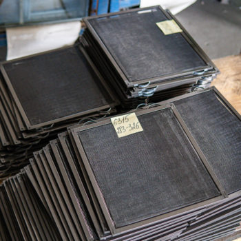 A stack of black trays on a table.