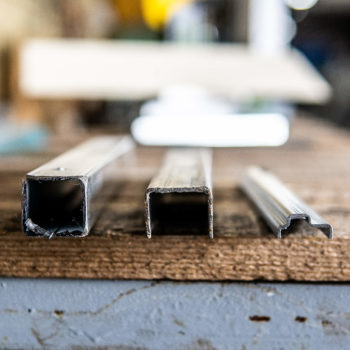 A metal square shaped objects on a wood surface.