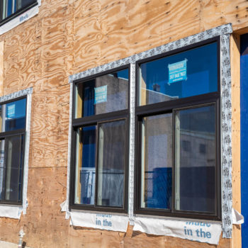 A building under construction with blue doors and windows.