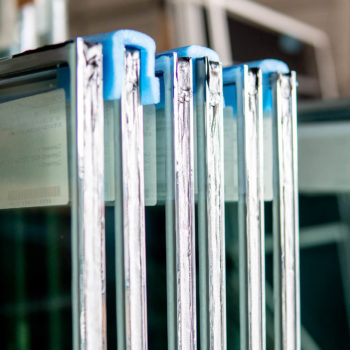 A row of glass window frames in a warehouse.